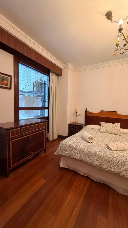 La cama, con la lámpara de araña